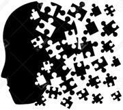 A black silhouette a face in profile breaking up into jigsaw pieces